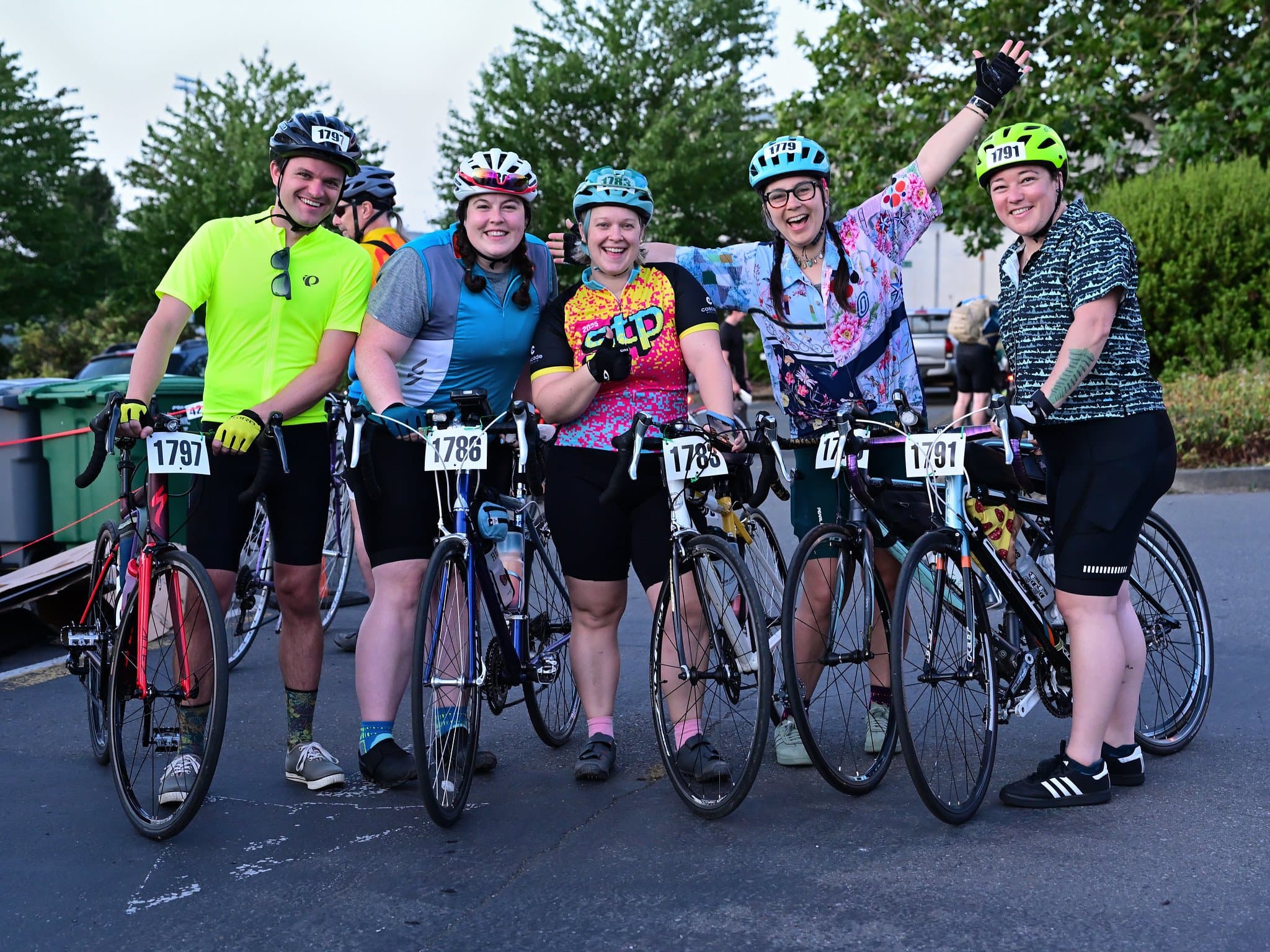 A group of happy riders of all sizes celebrate finishing STP in 2025.